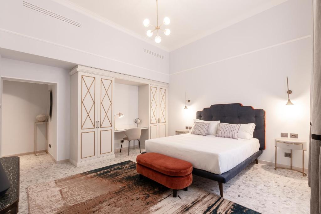 Dormitorio blanco con cama y taburete en Be Mate Castel Sant'Angelo, en Roma