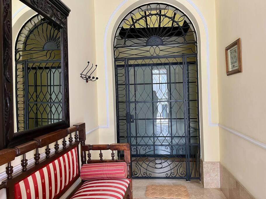 einer Bank vor einer Tür mit einem Tor in der Unterkunft Apartamento Suite Alameda de Hercules in Sevilla