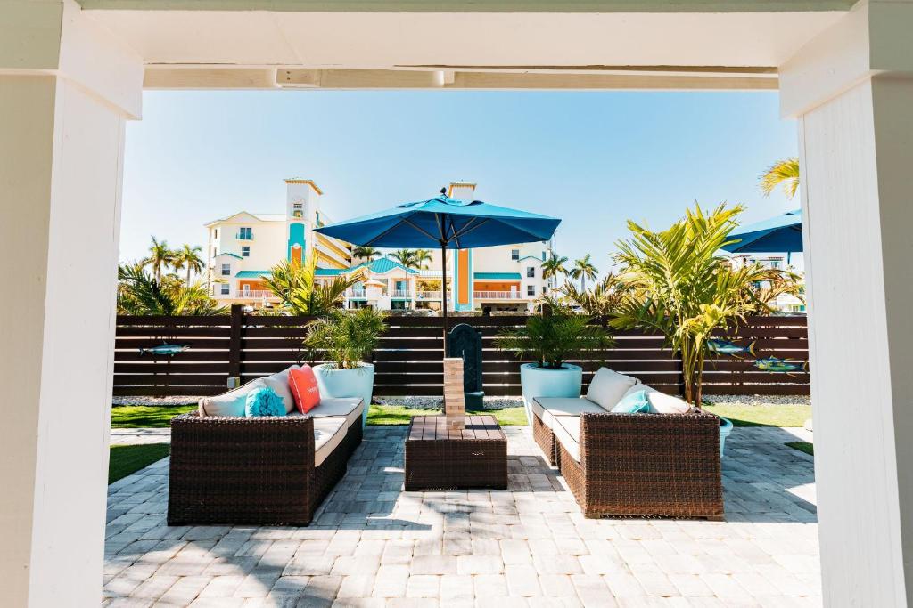 a patio with two couches and an umbrella at Cabanas of Treasure Island in St. Pete Beach