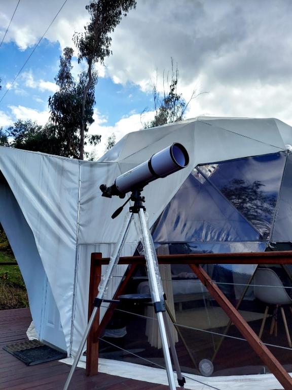 a telescope on a tripod next to a tent at Golden Glamping in Guatavita