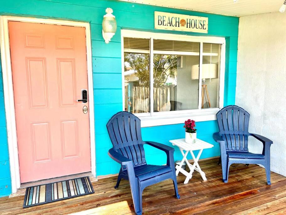 two chairs and a table in front of a house at Beach Bungalow in downtown Cocoa Beach in Cocoa Beach