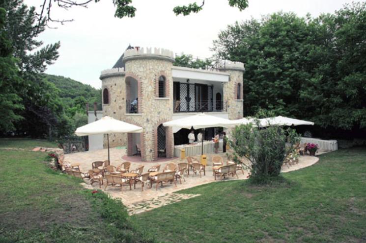 een huis met stoelen en parasols ervoor bij B&B Villa Torri Petrose in Pontelatone