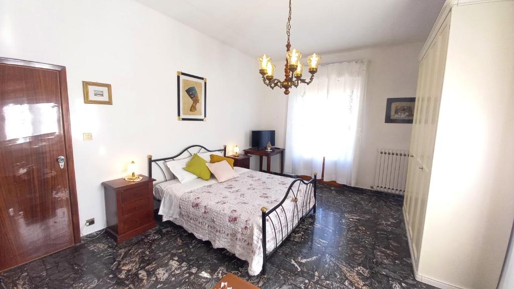 1 dormitorio con cama y lámpara de araña en OPERA21 TUSCANY SINGLE HOUSE LUCIGNANO, en Lucignano