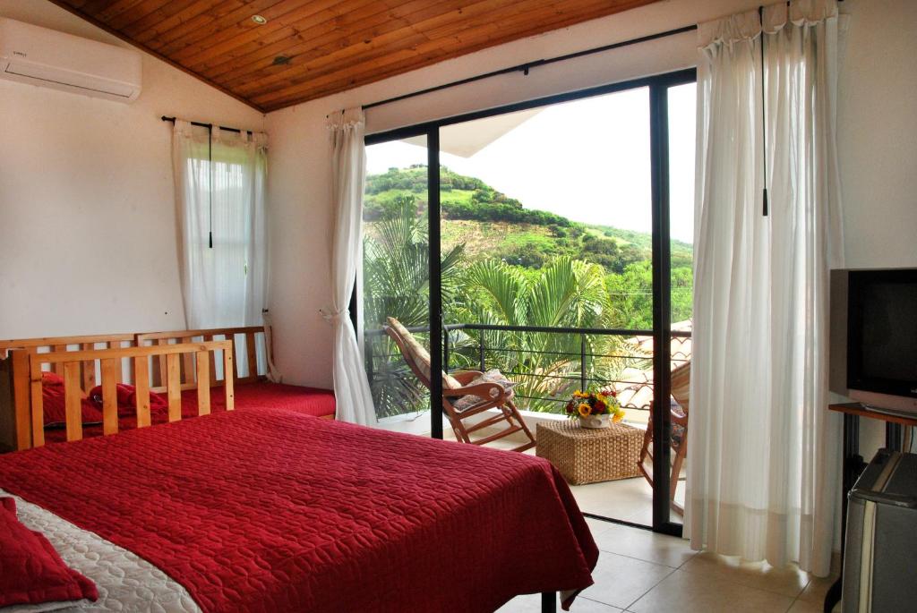 a bedroom with a red bed and a sliding glass door at Incluye auxiliar doméstica PISCINA PRIVADA in Girardot