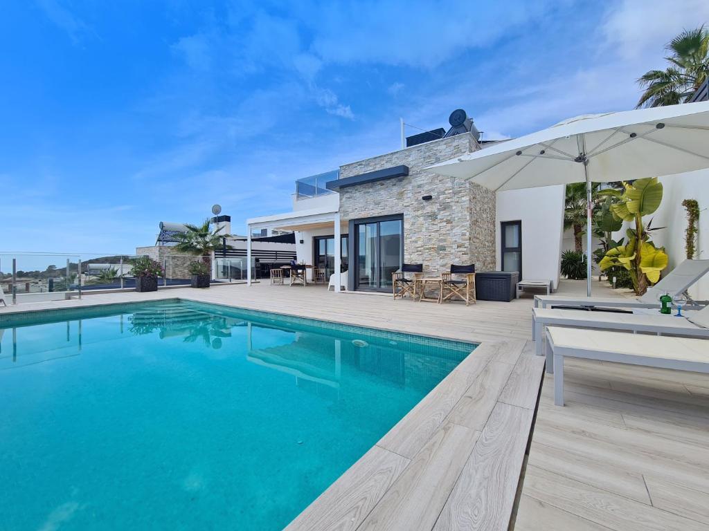 eine Villa mit einem Pool und einem Haus in der Unterkunft Hillside Luxury Villas by NRAS in Finestrat