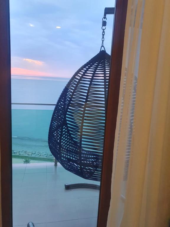 een hangende vogelkooi wordt gezien door een raam bij The Fresh Wave hotel in Batoemi