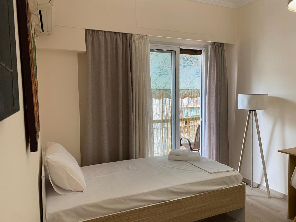Bett in einem Zimmer mit Fenster in der Unterkunft Acropolis Luxury Apartments in Athen
