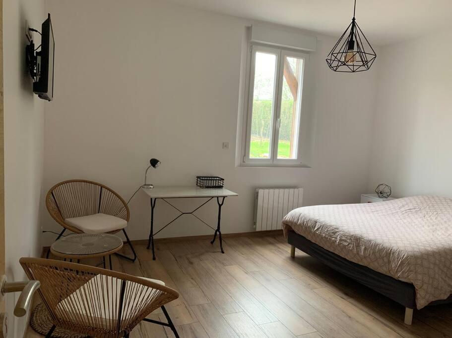 sypialnia z łóżkiem, stołem i krzesłem w obiekcie Gîte, Maison entière avec billard et bel espace de vie La Grange w mieście Blicourt