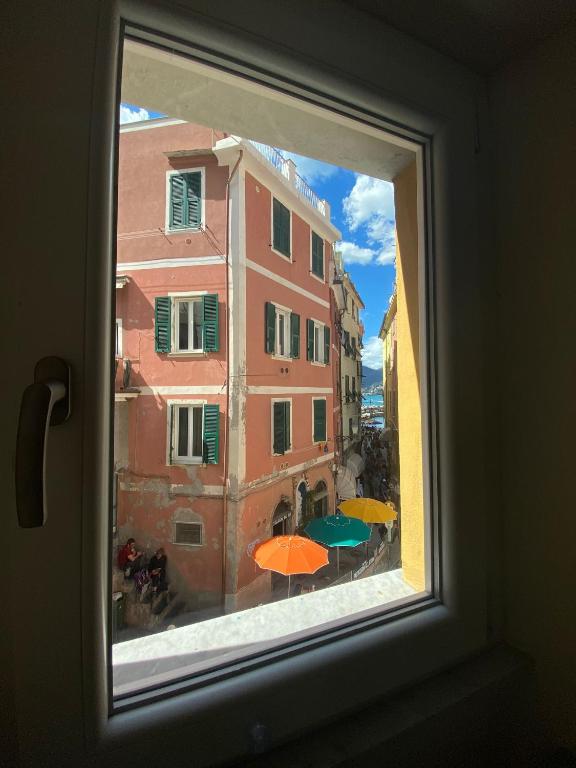 a window with a view of a building with umbrellas at LUVEGU SCIUIU Apartment in Vernazza