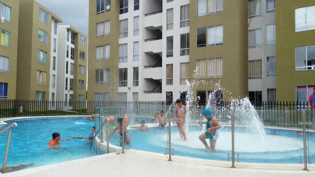 een groep kinderen die spelen in een zwembad met fontein bij Apartamento Villavicencio in Villavicencio