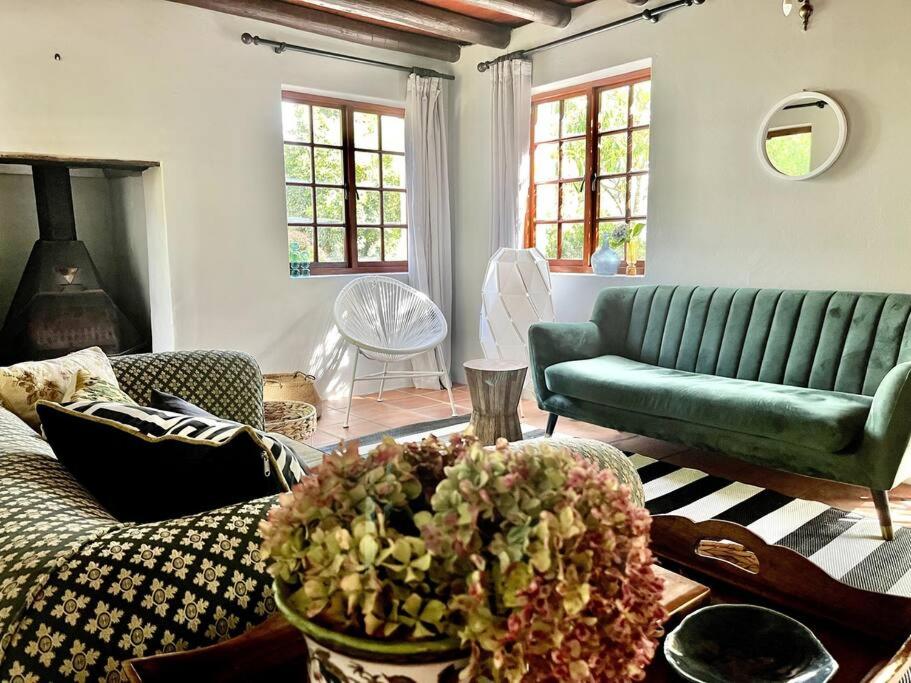 a living room with a green couch and a table at Comfy Greyton Cottage for Four in Greyton
