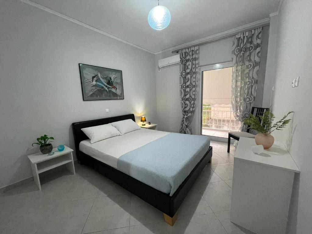 a bedroom with a large bed and a window at Cozy Apartment in Nea Palatia-Oropos in Oropos