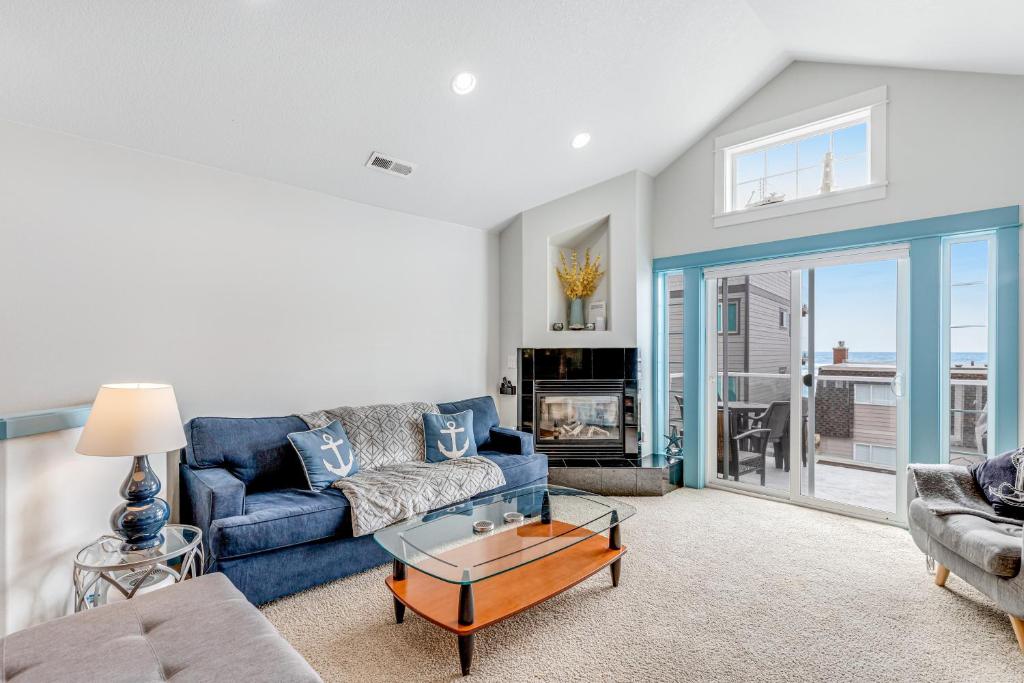 a living room with a blue couch and a table at EazyBreezy in Rockaway Beach