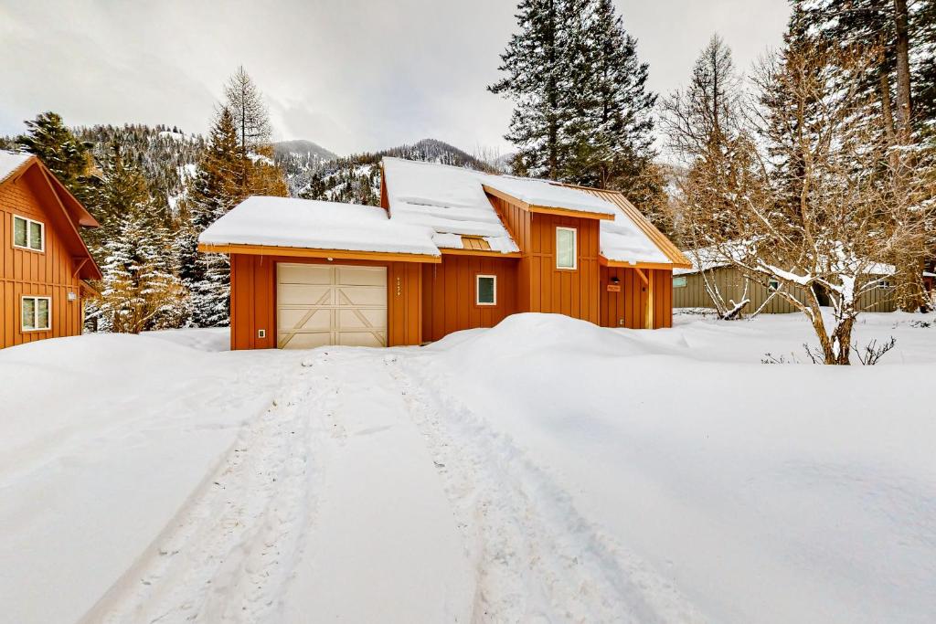 a house covered in snow with a driveway at Wallowa Lake Wonder in Joseph