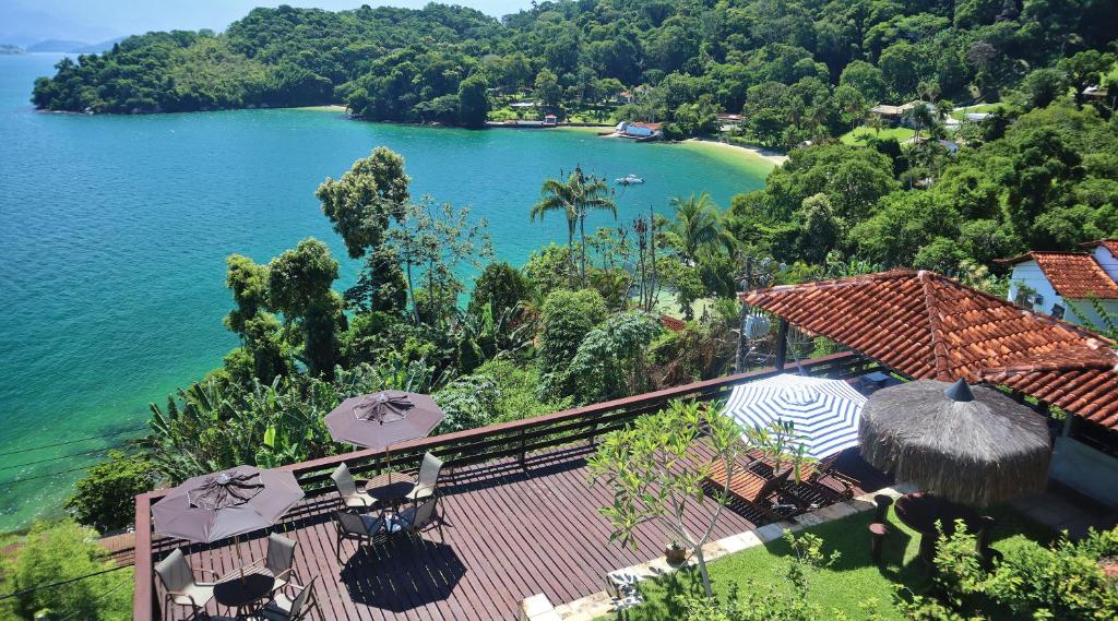a view of a lake from a house with umbrellas at Mirante da Figueira - Suítes para temporada in Angra dos Reis