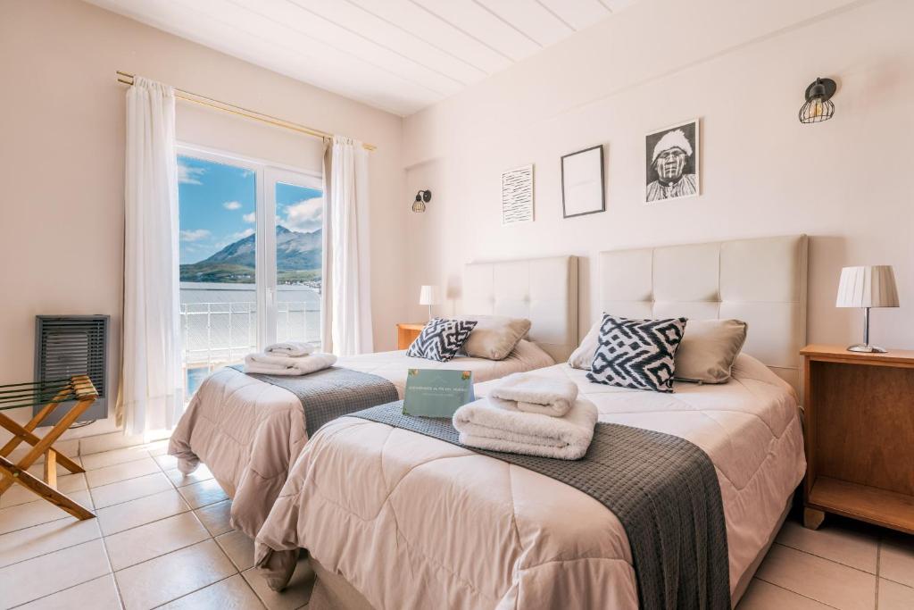 two beds in a room with a window at Riviera Fueguina Apartments in Ushuaia