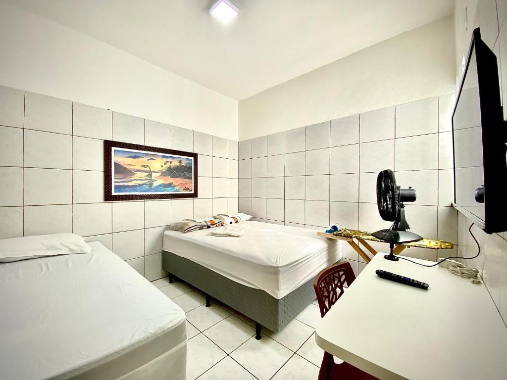 a room with two beds and a sink and a desk at 202 Kitnet no centro com wifi in Aracaju