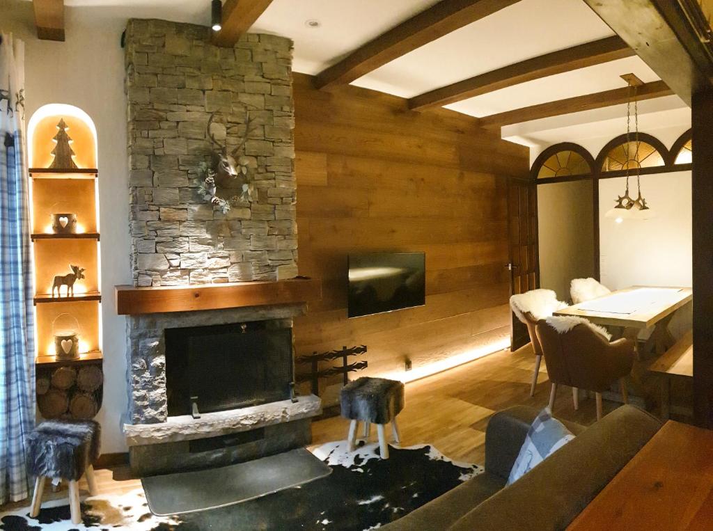 ein Wohnzimmer mit Kamin und ein Esszimmer in der Unterkunft Casa Matilda - Apartamento con chimenea, vistas, rustico-elegante en el centro in Sant Joan de les Abadesses