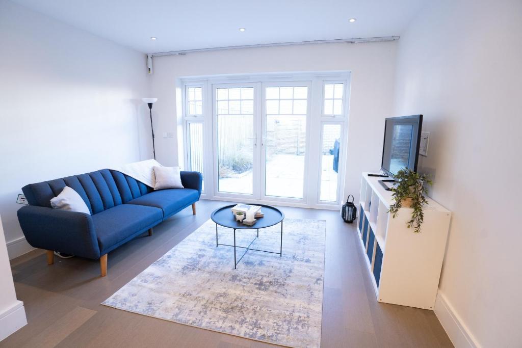 uma sala de estar com um sofá azul e uma mesa em Longwater Avenue em Reading