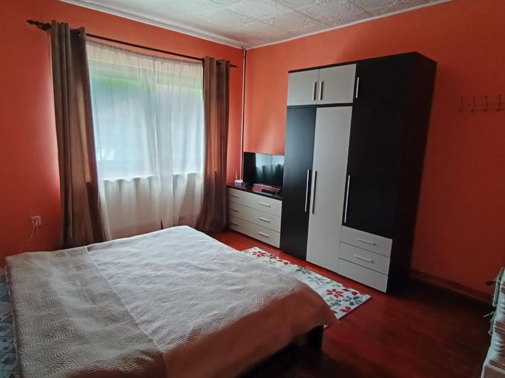 a bedroom with a bed and a tv and a window at Casa La Măriuca in Bran