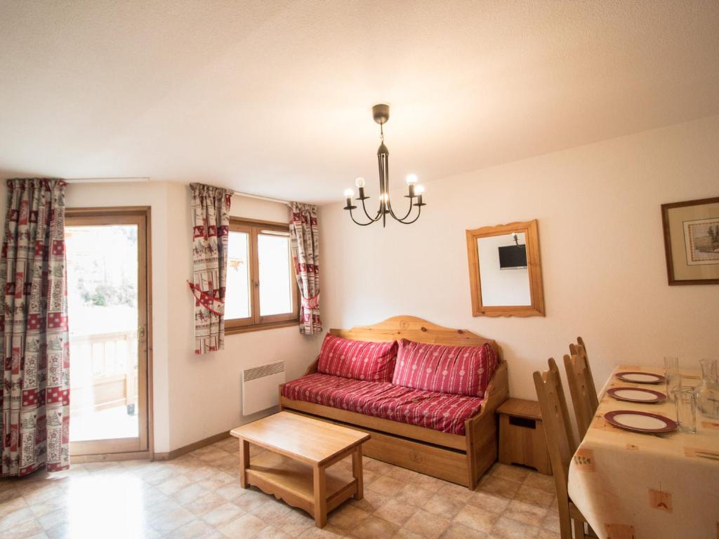un salon avec un canapé rouge et une table dans l'établissement Spacieux appartement 6 pers au pied des pistes avec balcon et parking – Val-Cenis - FR-1-508-8, à Lanslevillard