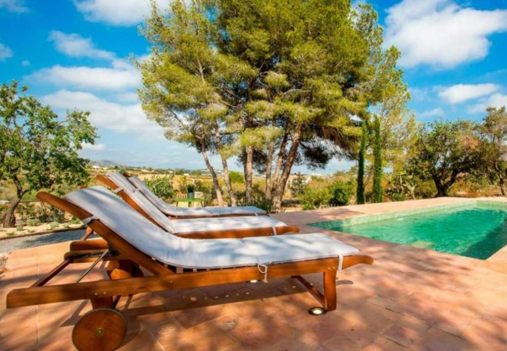 - deux chaises longues sur une terrasse à côté de la piscine dans l'établissement Toscana, à Benissa