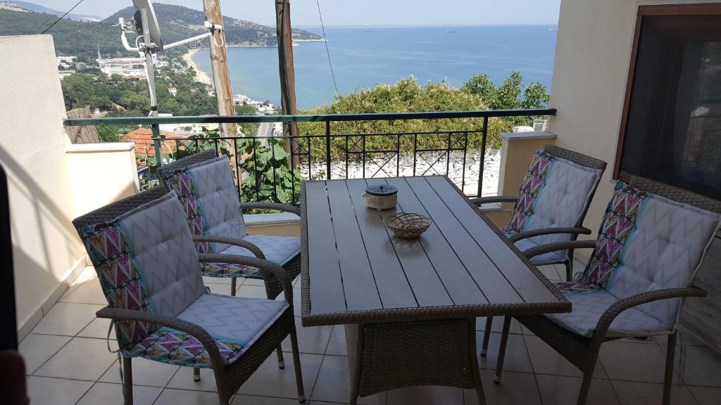 een houten tafel en stoelen op een balkon bij THE VIEW APARTMENT KAVALA in Kavala