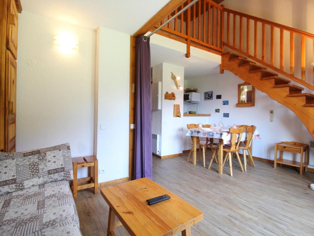 un salon avec un escalier et une table dans l'établissement Duplex pour 8 pers avec balcon et wifi au pied des pistes - FR-1-508-79, à Termignon