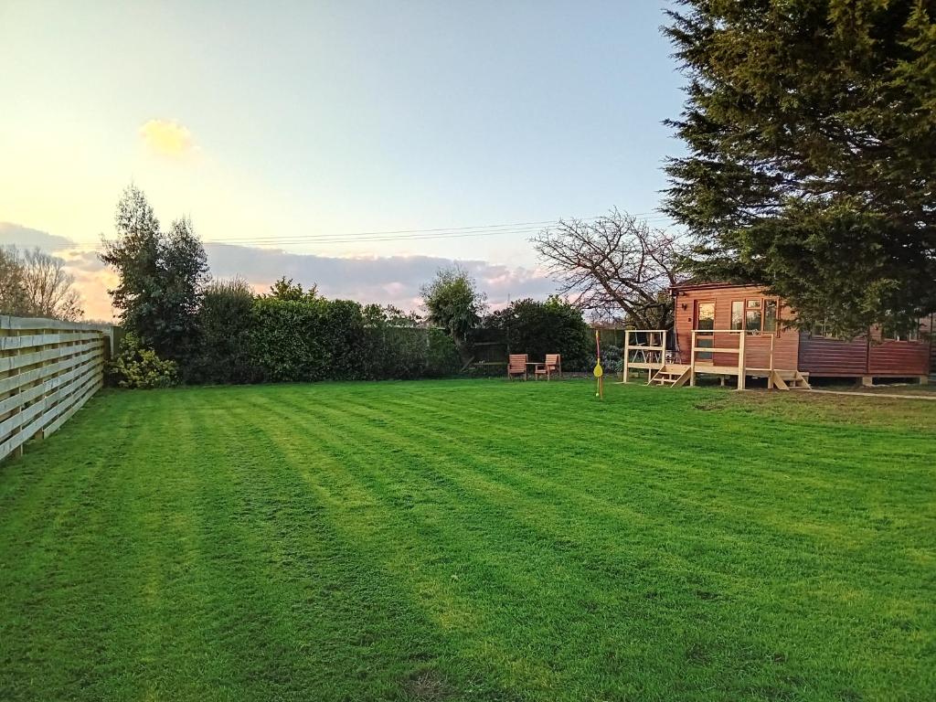 a yard with a fence and green grass at Love Nest in Deal