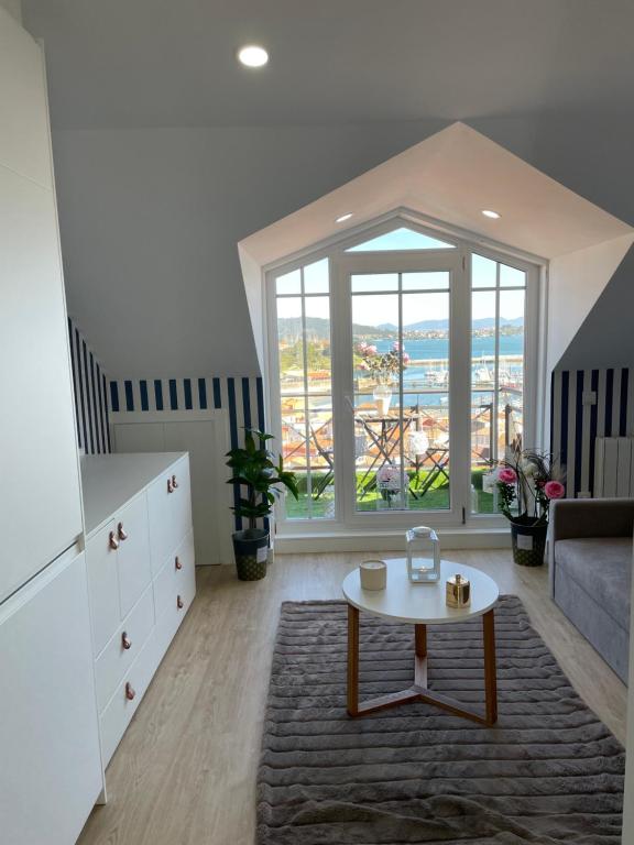 a living room with a table and a couch at Estudio impresionantes vistas con terraza y piscina in Baiona