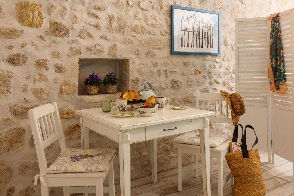 a white table and chairs with a bowl of fruit on it at Stayeva 11 in Dubrovnik