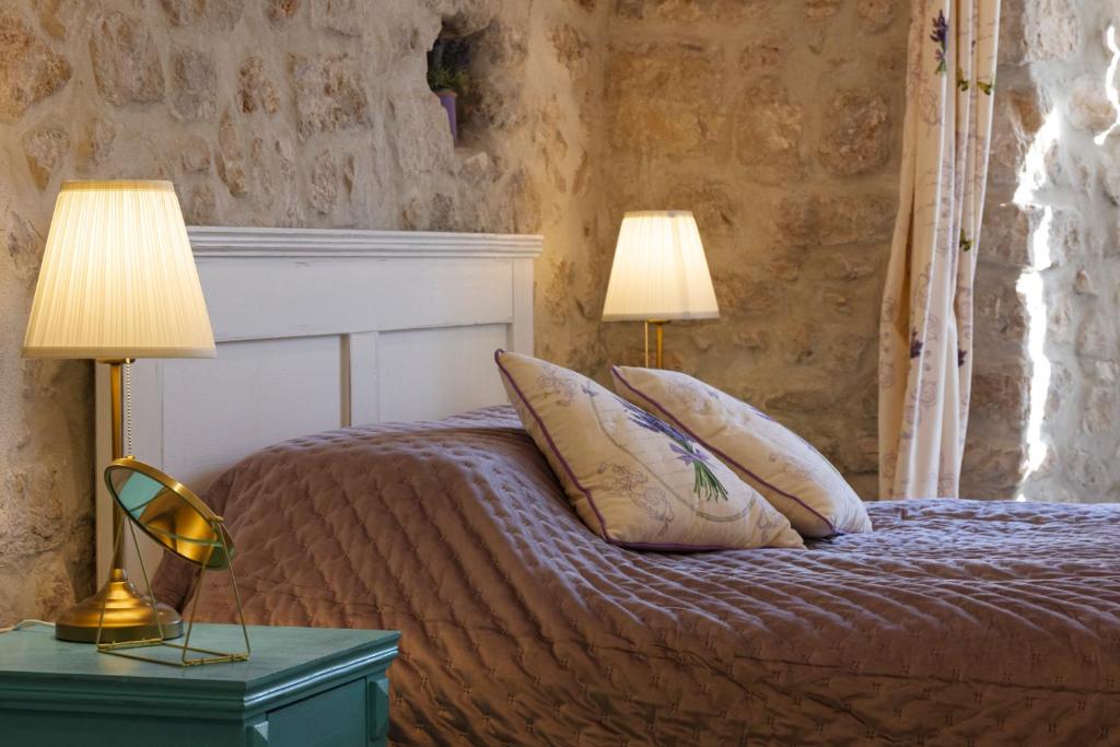 a bedroom with a bed with two lamps on it at Stayeva 11 in Dubrovnik