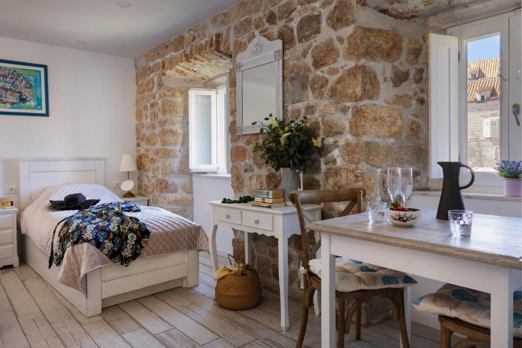 a bedroom with a bed and a stone wall at Stayeva 11 in Dubrovnik