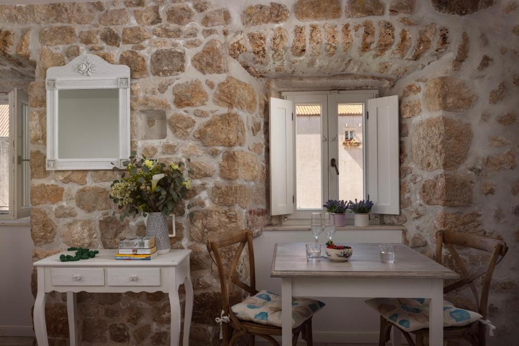 a room with two tables and a stone wall at Stayeva 11 in Dubrovnik