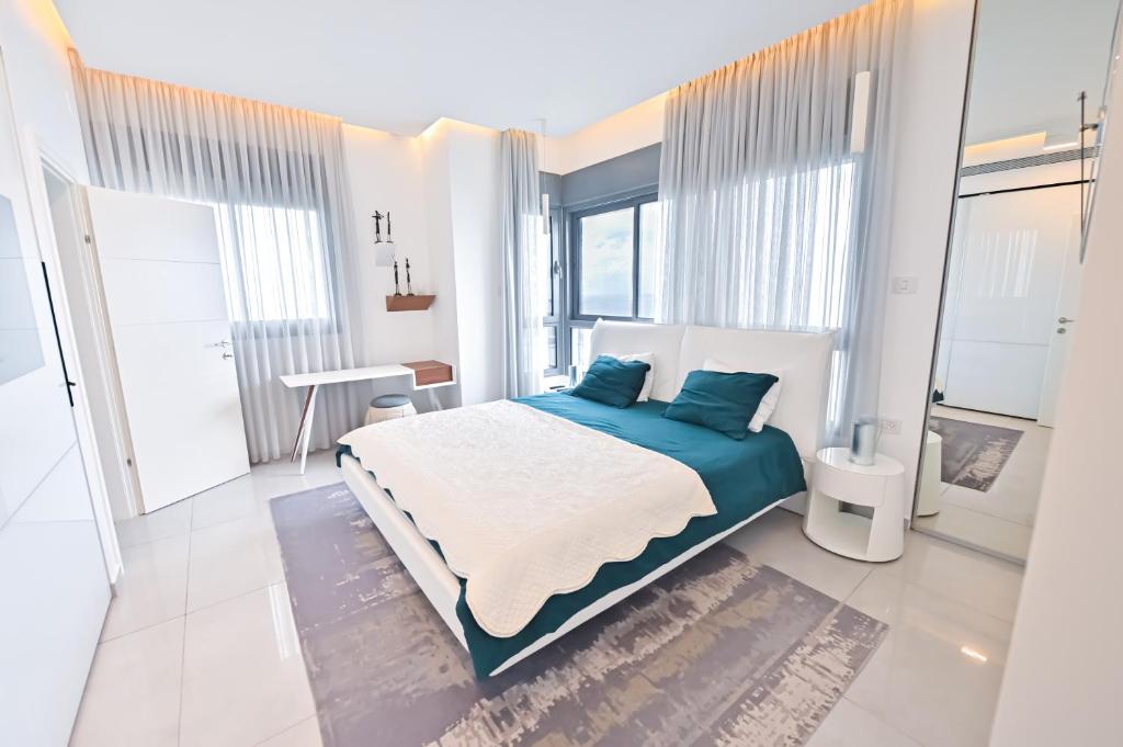 a bedroom with a large bed with blue pillows at Apartment Fabulous in Bat Yam