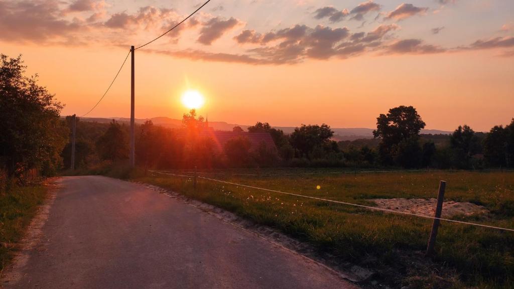 レシナにあるGórska Ostoja pole kempingowo- kamperoweの夕日を背景にした未舗装道路