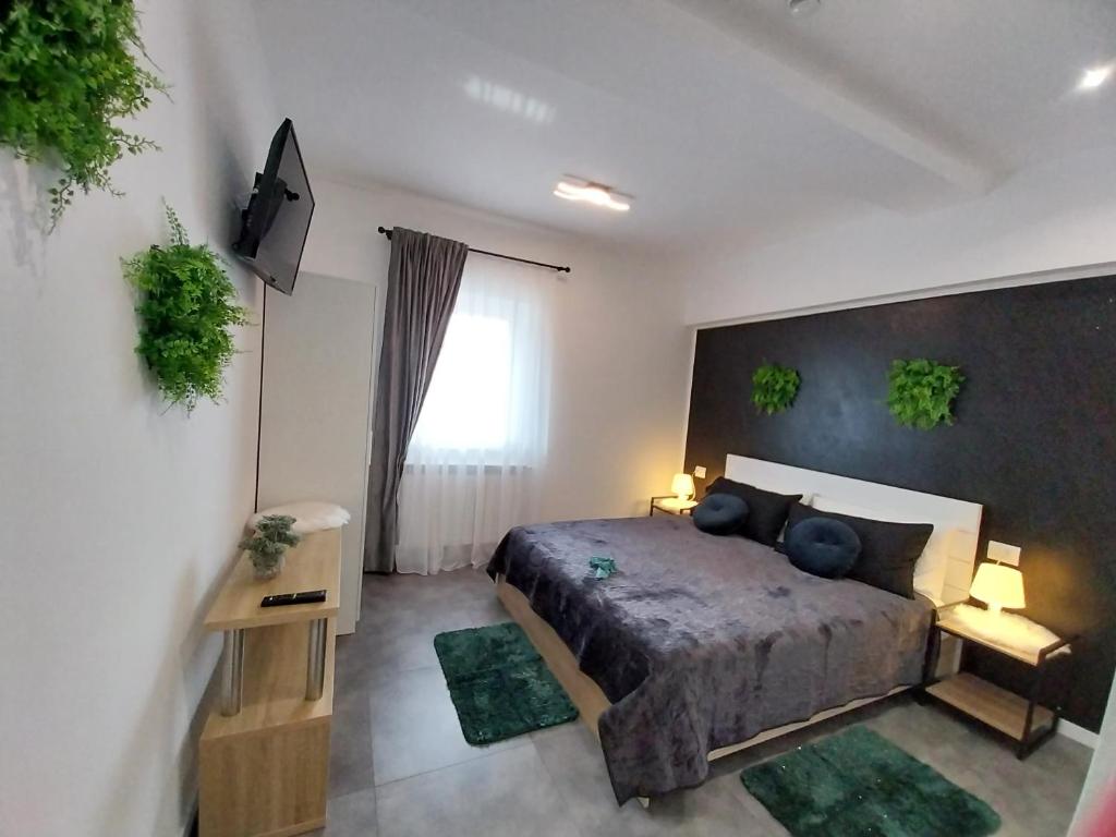 een slaapkamer met een bed en twee tapijten bij Pensiunea Ideal in Băile Borşa