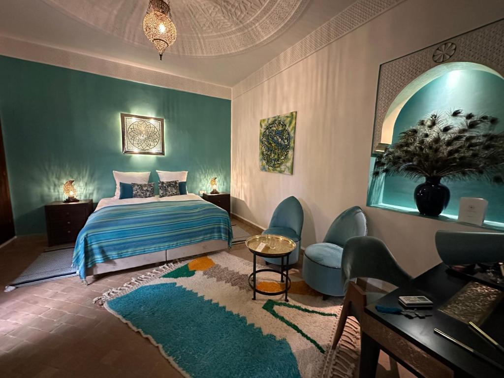 1 dormitorio con 1 cama, mesa y sillas en La Claire Fontaine, en Marrakech