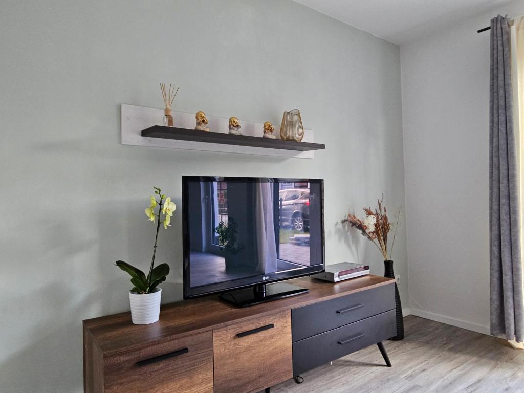 a living room with a flat screen tv on a dresser at Ferienwohnung - Melina - in Winsen