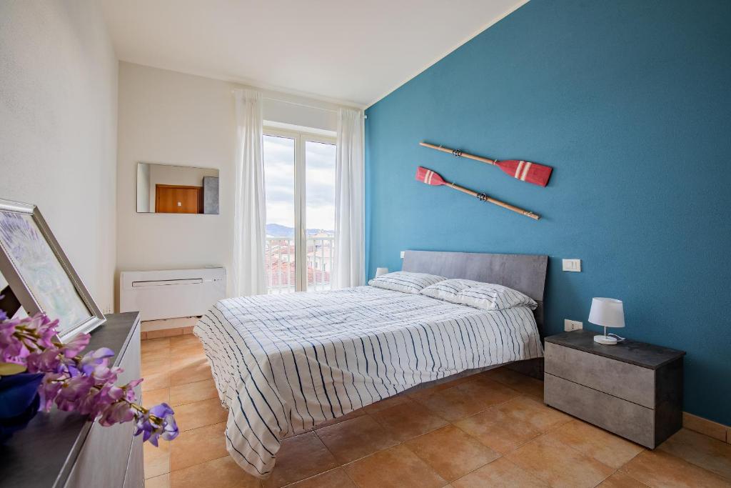a bedroom with a bed and a blue wall at Pretty house in Viareggio