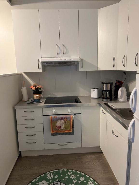 a kitchen with white cabinets and a stove top oven at Studio in Rovaniemi