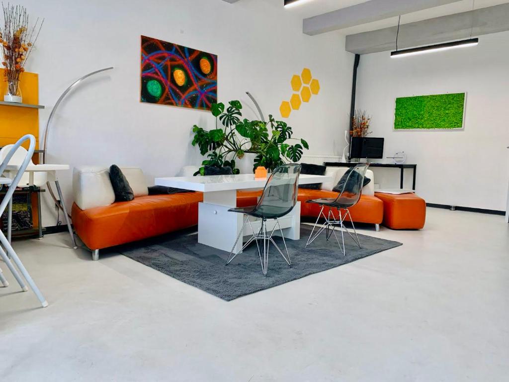 een woonkamer met een oranje bank en stoelen bij Design Family Apartment in Leiden Center 6p & baby in Leiden