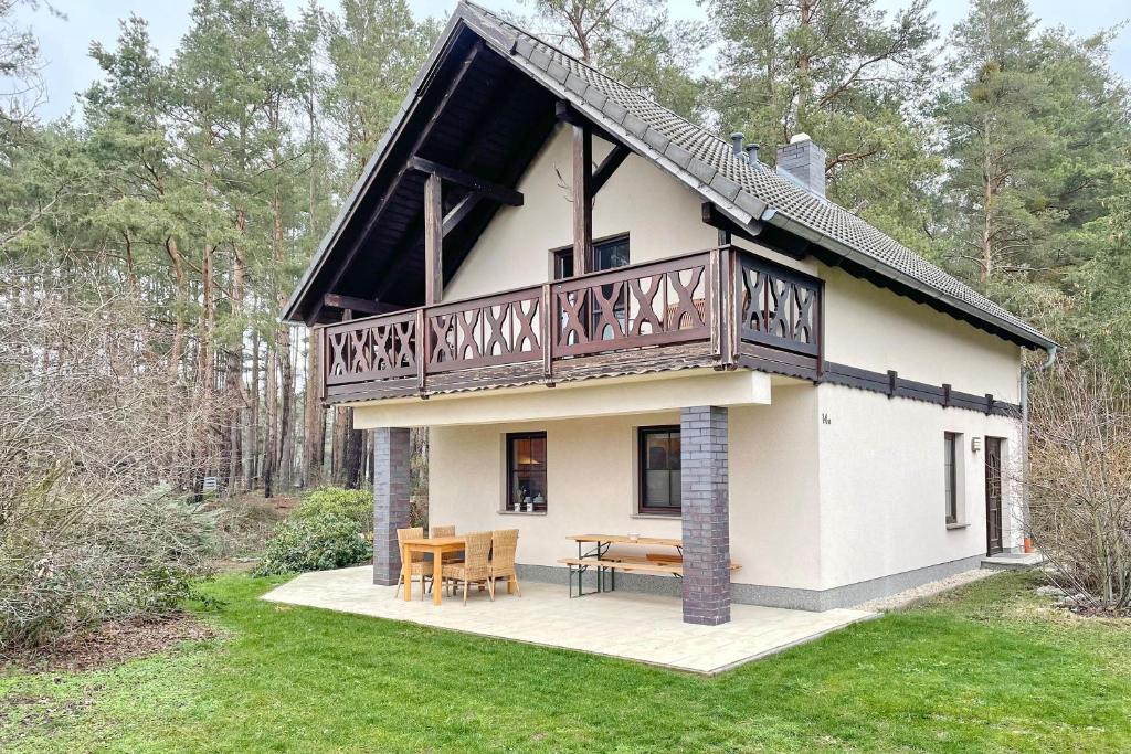 una grande casa bianca con balcone e tavolo di Ferienhaus Kiefernwäldchen a Byhlen