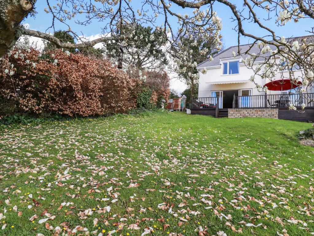 a house with a yard with flowers in the grass at Chy Ryn in Par