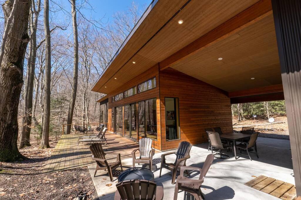 a screened in porch of a house with chairs and a grill at Malaya Dunes Walk To Laketown Beach in Holland