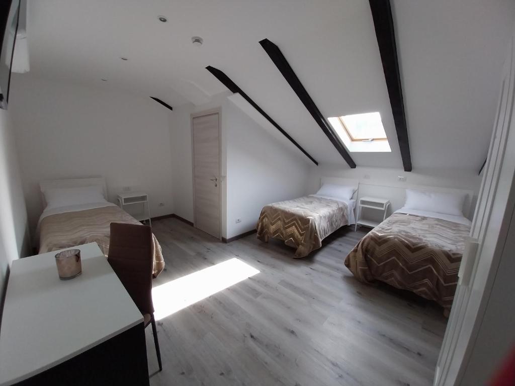 a attic room with two beds and a table at PENSIUNEA IDEAL in Băile Borşa