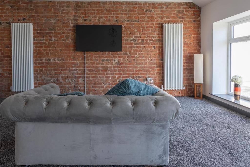 a couch in a room with a brick wall at RESIDENCY LUXURY SEAFRONT HOTEL in Blackpool