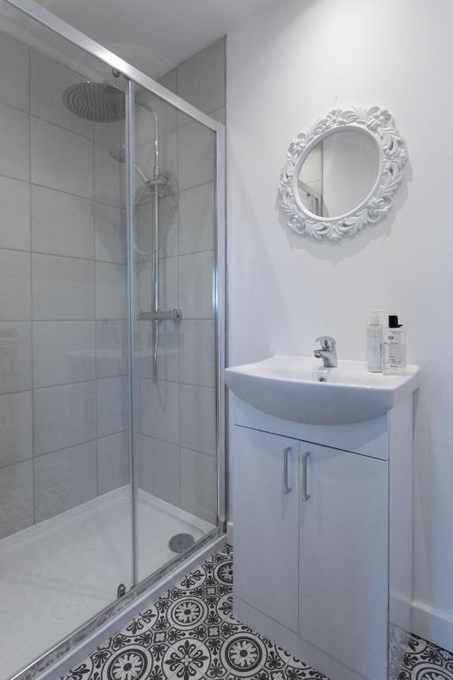 a bathroom with a shower and a sink and a mirror at RESIDENCY LUXURY SEAFRONT HOTEL in Blackpool