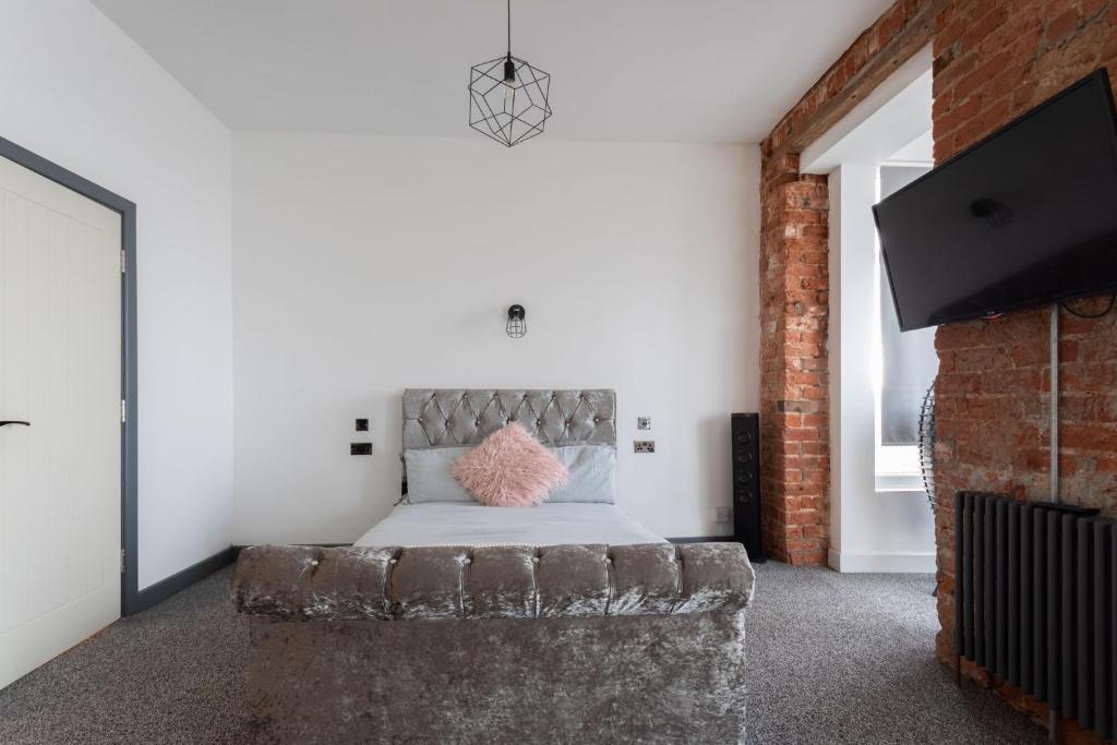 a bedroom with a bed and a brick wall at RESIDENCY LUXURY SEAFRONT HOTEL in Blackpool