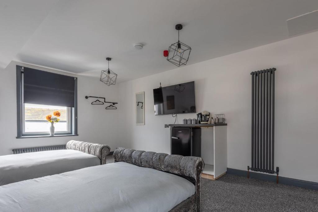 a hotel room with two beds and a window at RESIDENCY LUXURY SEAFRONT HOTEL in Blackpool